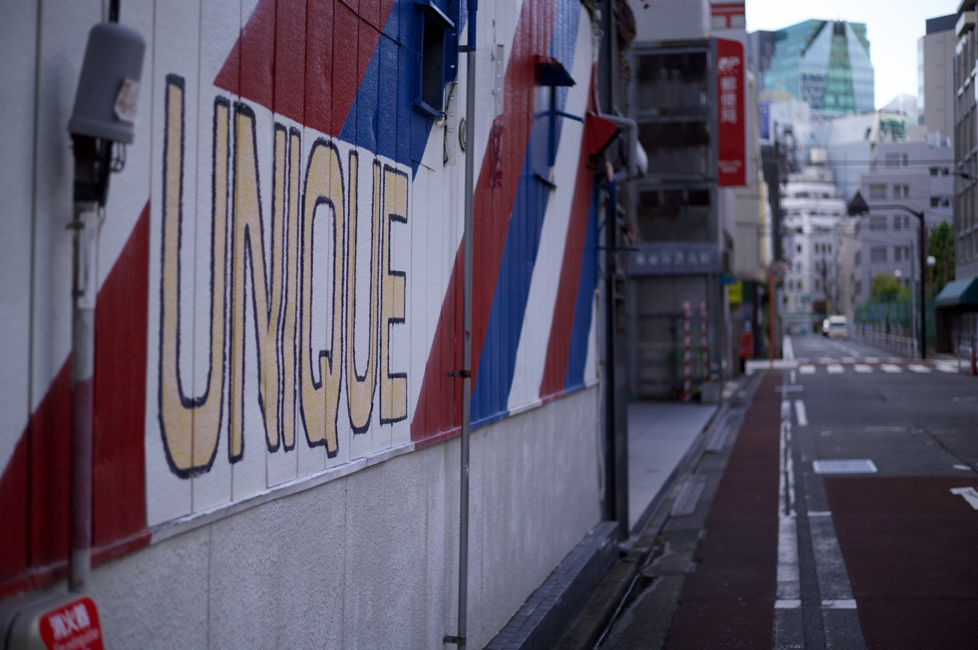 UNIQUEの文字が描かれた壁と街並みのスナップ